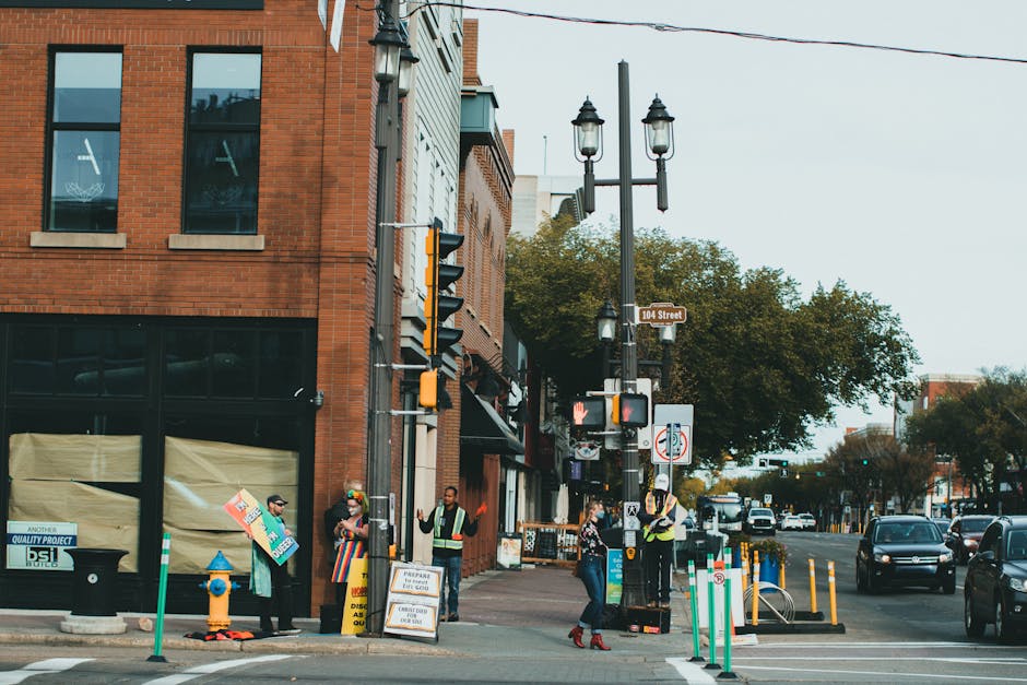 Street view of a bustling urban intersection with pedestrians and brick buildings.